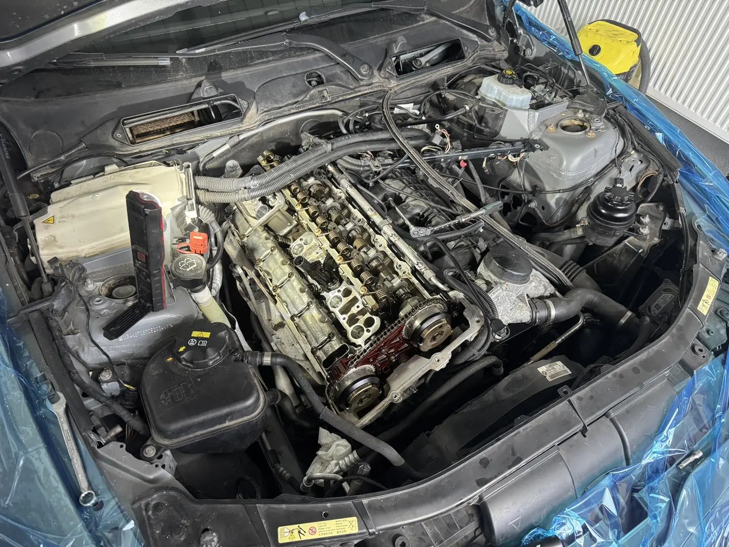 Zbliżenie na układ silnika BMW podczas naprawy.